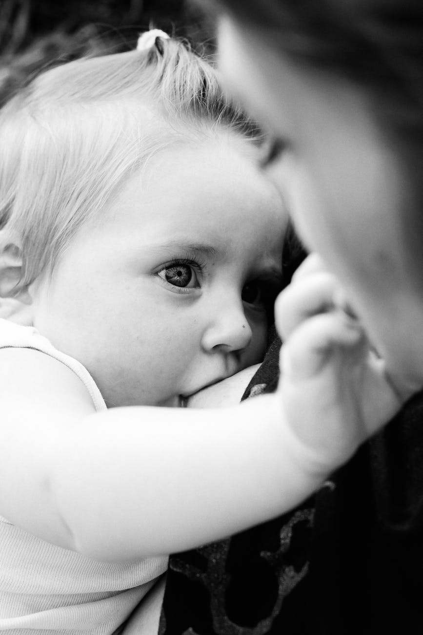 black and white photo of woman breastfeeding her baby