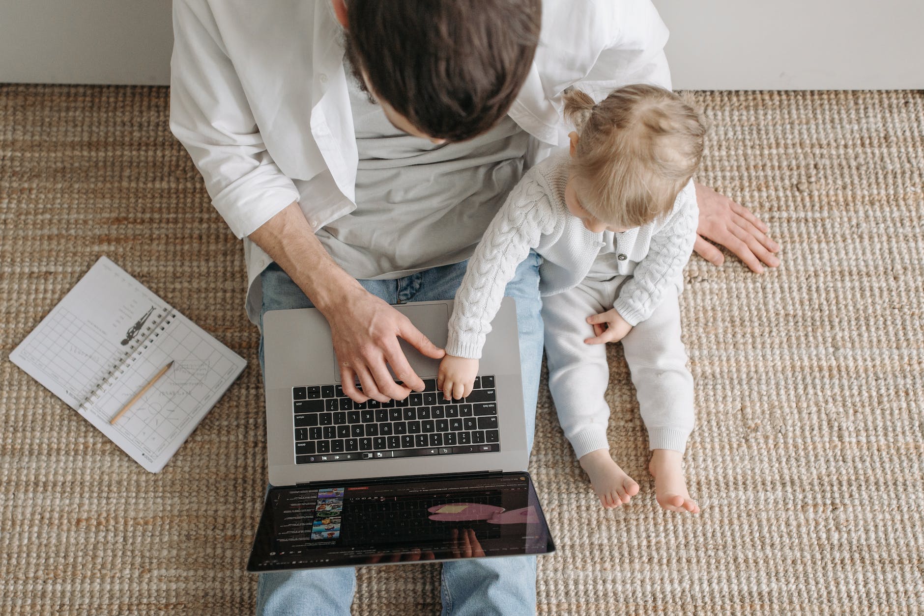a blonde baby touching the laptop keyboard